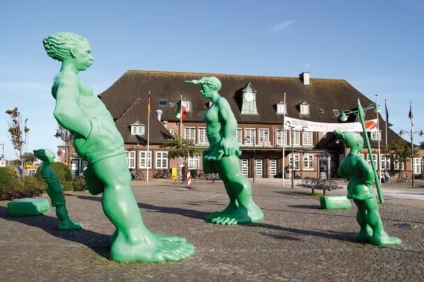 Die grünen Skulpturen Reisende Riesen auf dem Vorplatz des Bahnhofs in Westerland